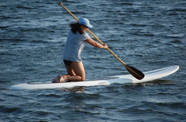 mujer realizando sup de rodillas